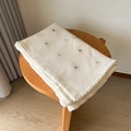Chunky knit off-white sofa blanket with colorful polka dots on a wooden stool - 140x100CM / Speckled Beige
