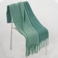 Écharpe vert menthe en imitation cachemire avec franges drapée sur une chaise - vert clair