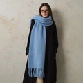 Sciarpa spessa in misto lana blu acceso con frange indossata su un cappotto nero - Blu ciano