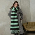 Chic mint green and grey striped scarf with tassels shown on a model in a warm studio - Cyan And Black Striped