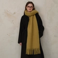 Classic mustard yellow wool blend scarf with tassels shown on black coat - Khaki
