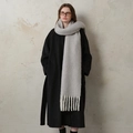 Chic light grey thick wool scarf with long tassels worn over a black winter coat - Blue Mist Gray