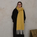 Thick bright yellow wool scarf with long white tassels shown on a grey coat - Maple Yellow (Golden Brown)