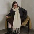 Creamy white wool knit scarf with fringe tassels shown on a model in autumn style - Cream