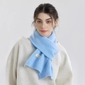 Sciarpa in maglia celeste con etichetta minimalista indossata da una modella - Celeste
