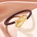 Braided snake head bracelet with gold hollow metal and green gemstone eyes in brown - Brown