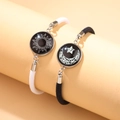 Bracelets de couple tressés Soleil et Lune lumineux sur un support de présentation rose - Noir Blanc Soleil Lune Ensemble