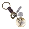Porte-clés signe Gémeaux en cuir tressé vintage avec breloques en bronze et plaque gravée - Gémeaux