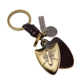 Portachiavi vintage con scudo e croce in bronzo e pelle marrone su sfondo bianco - Bronzo Antico