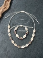 Platliggende set van handgemaakte schelpenketting en armband op stenen achtergrond - Schelpen Set