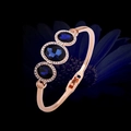 Eleganter roségoldener Armreif mit drei dunkelblauen Kristallen und Diamantbesatz - Roségold