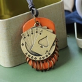 Ciondolo poker vintage con base in pelle arancione e metallo bronzo su cordoncino marrone - caffè