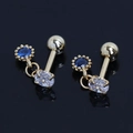 Gros plan de boucles d'oreilles en acier doré avec zircons ronds bleus et ovales clairs - Or Strass Bleu