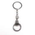 Macro-opname van retro schedel hand hanger met een gedraaide ring aan sleutelhanger - Zilver