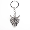 Dettaglio del portachiavi a maschera Hannya in metallo argentato con corna e zanne - Argento