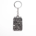 Macro detail of silver dragon totem relief on rectangular metal keychain pendant - Silver