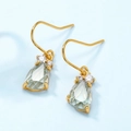 Detailed close-up of 18K gold drop earrings with green teardrop crystal and white stones - 925 Silver / Synthetic Green Amethyst