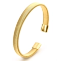 Macro shot of 18K gold C-shaped cuff bracelet with detailed flexible spring-like texture - 8mm Wide / Gold