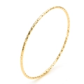 Close-up of golden titanium steel bangle with elegant diamond-cut texture and shiny finish - Gold