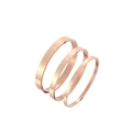 Dettaglio di un set di tre bracciali rigidi in acciaio inossidabile lucido oro rosa in varie larghezze - 4mm / Oro rosa