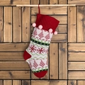 Chaussette de Noël tricotée avec sapins et flocons sur un décor de mur en bois - Haut Rouge