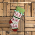 Chaussette de Noël tricotée avec motifs flocons rouges et pompons verts sur bois - Haut Vert