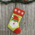 Grande chaussette de Noël verte avec applique Père Noël suspendue sur un mur en bois - Père Noël