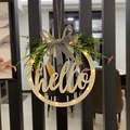 Close-up of wooden Easter welcome wreath with warm LED lights and a black plaid bow - Hollow Hello With Light