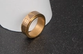 Detailed view of golden rotatable ring with Nordic runes and brushed metal texture - US Size 7 / Gold