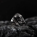 Vintage punk silver skull ring with spiral horns on a dark rock background - Silver J (Monster Skull Style)