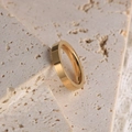Minimalist gold polished stainless steel couple ring on a white travertine stone background - US Size 4 / Gold