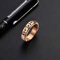Dettaglio di anello girevole in oro rosa con motivi incisi di stelle e lune nere - Taglia US 7 / Oro rosa