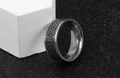 Macro detail of Nordic vintage Celtic knot pattern on stainless steel ring surface - Black Silver