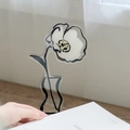 Acrylic flower photo clip with checkerboard pattern on a wooden desk with soft window light - Poppy