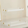 Close-up of a double-tier clear acrylic shelf with elegant gold metal support accents - Frosted Clear Style