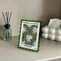 7-inch green scalloped magnetic acrylic frame with white daisy floral art on a desk - Green