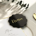 Macro shot of wavy black acrylic wedding place card with gold Maria custom text - Wavy Transparent