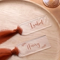Macro shot of custom acrylic wedding place cards with elegant chiffon tassels and leaf patterns - Rectangular Transparent