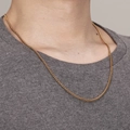Goldene Weizenkette aus Edelstahl am Hals getragen für einen modernen Unisex-Look - Goldene Blumenkorbkette