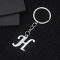 Silver metal letter H keychain with crystal rhinestone inlay on a dark background - Letter H