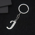 Silver letter J keychain with sparkling rhinestones on black glitter background - Letter J