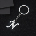 Silver metal letter N keychain with rhinestones on a textured black background - Letter N