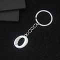 Silver letter O keychain with inlaid crystals on a premium textured black surface - Letter O