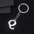 Silver letter e keychain with sparkling rhinestones on a stylish black background - Letter Q
