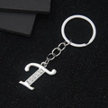 Silver letter T keychain with crystal rhinestones on black textured background - Letter T