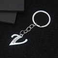 Polished silver metal letter V keychain with sparkling rhinestones on black background - Letter V
