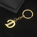 Golden keychain featuring letter D with sparkling crystals on black textured background - Letter D Style / Gold