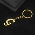 Golden alphabet G keychain with rhinestone inlay on a textured black background - Letter G Style / Gold