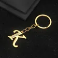 Golden letter K keychain with inlaid white rhinestones on a textured black background - Letter K Style / Gold
