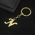 Golden letter N keychain with sparkling rhinestones on a black textured surface - Letter N Style / Gold